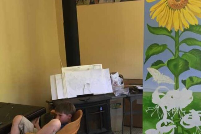 Phoenix reads next to Seemanta's mural In progress